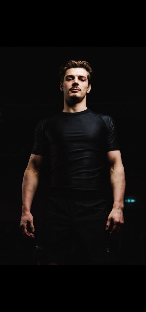 Hugo Dvorecky in a black rash guard, photographed against a black background